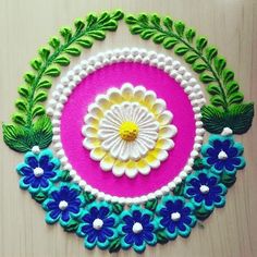 a colorful piece of art made out of felt with flowers and leaves on the side