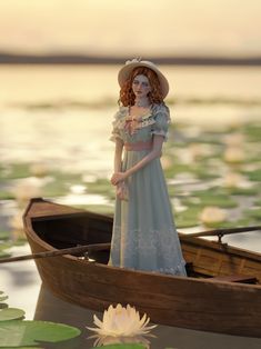 a woman in a blue dress and hat standing on a boat with lily pad water lilies