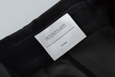 a label on the back of a black jacket that says, deconfoered