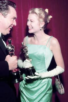 a woman in a green dress holding an award