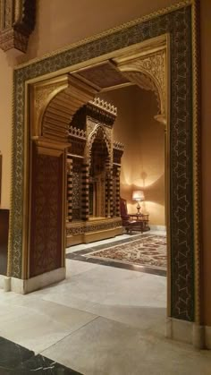 an ornate doorway leading to a living room with a large rug on the floor and walls