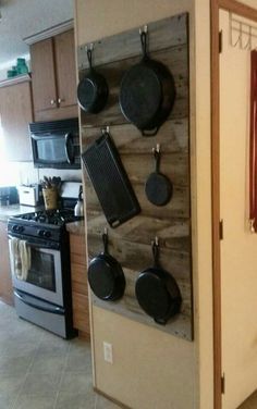 a kitchen with pots and pans hanging on the wall next to stove top oven