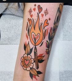 a woman with a tattoo on her arm that has flames and hearts around it,