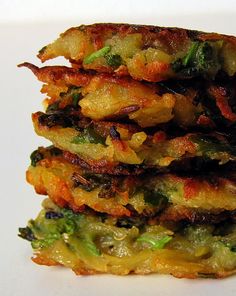 a stack of food sitting on top of a white plate covered in broccoli