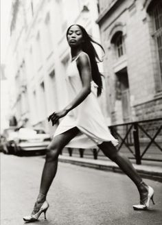 a woman is walking down the street with her legs spread out in front of her