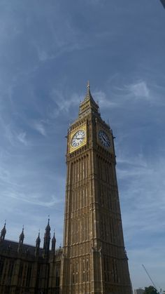 the big ben clock tower towering over the city of london on a sunny day with blue skies