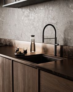 a kitchen sink sitting under a window next to a counter top with soap dispensers