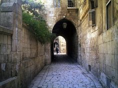 an alley way with cobblestones and stone walls