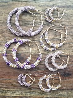 Hoop earrings with a mix of purple, gold and white beading. Lever back. -large hoops 2"x2" -medium hoops 1.5"x1.5" -small hoops 1.25x1.25 -extra small hoops 1x1 -mini hoops .75x.75 Bead Wrapped Hoop Earrings, Purple Earrings, Earrings Beaded, Beaded Hoop Earrings, Beaded Hoops, Amethyst Earrings, Jewelry Earrings Hoops, Purple Gold, Earrings Gold