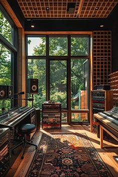 a recording studio with sound equipment and large windows overlooking the trees in the background is an area rug that looks like it has been made out of wood