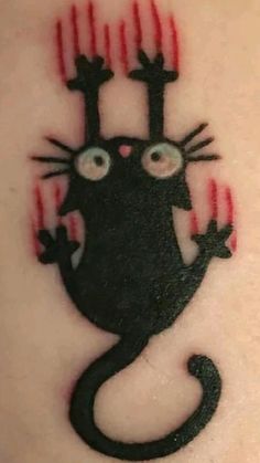 a black cat with red claws on it's head and eyes is depicted in this tattoo