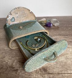 an open box with jewelry inside on a wooden table