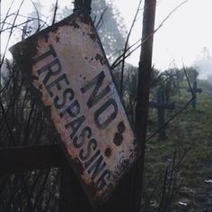 an old rusted sign that says no trespassing