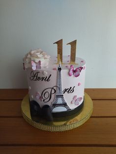 a birthday cake with the eiffel tower on it's side and pink flowers