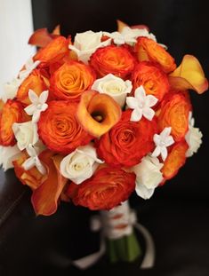 a bridal bouquet with orange and white flowers