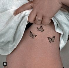 a woman's stomach with three butterflies on her side and the lower part of her abdomen