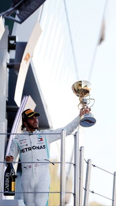 a man holding up a trophy on top of a boat