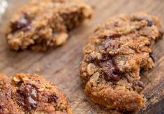 three chocolate chip cookies on a cutting board