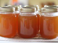 four jars filled with liquid sitting on top of a table