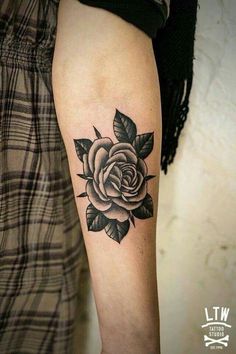 a black and white rose tattoo on the arm