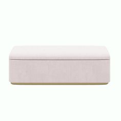 an upholstered bench with gold legs and a light pink fabric cover on it