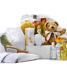 a teddy bear sitting in a white basket filled with baby products and personal care items