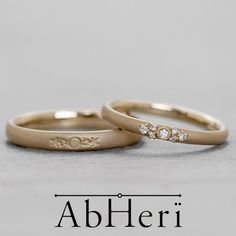 two gold wedding bands with diamonds on the bottom and an inscription above them that reads, ableri