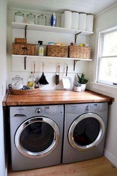 a washer and dryer in a small room with open shelving on the wall