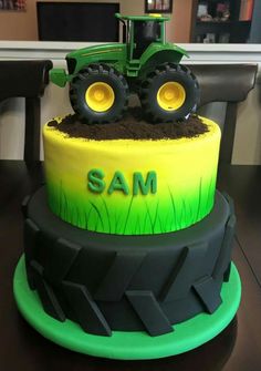 there is a cake with a tractor on it and the words sam written in green