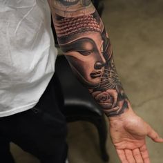 a man with a tattoo on his arm holding out his hand to touch the wrist