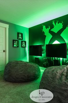 a room with two bean bags on the floor in front of a television and green lighting