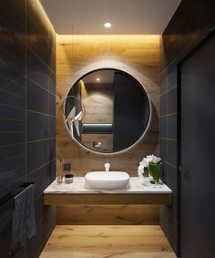 a bathroom with a round mirror above the sink and wooden walls, along with a white countertop