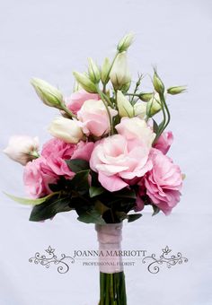 a vase filled with pink and white flowers on top of a wooden table next to an instagram page