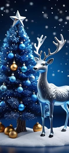 a silver reindeer standing next to a blue christmas tree with gold and silver ornaments on it