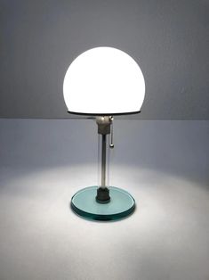 a table lamp sitting on top of a blue plate with a white light in the middle