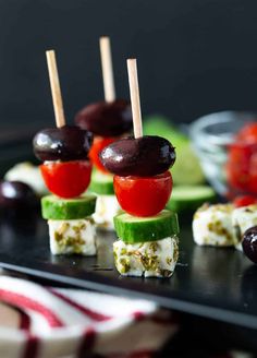 small appetizers with olives, tomatoes and cucumber on a tray