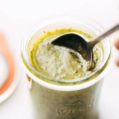 a spoon in a jar filled with green liquid