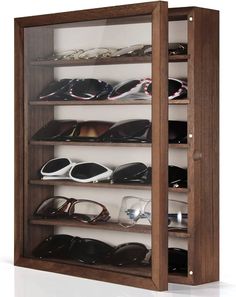 a wooden shelf with several pairs of shoes on top of it and glasses in the bottom