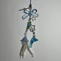 a keychain with charms attached to it on a white surface, including a dolphin and starfish