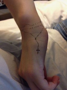 a person with a cross tattoo on their foot