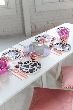 a white table topped with pink and black plates