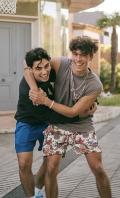 two young men hugging each other on the street