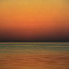 an orange and yellow sunset over the ocean