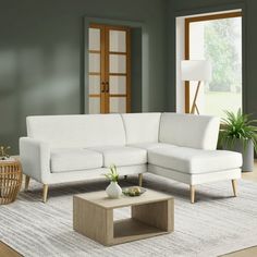 a living room with green walls and white furniture