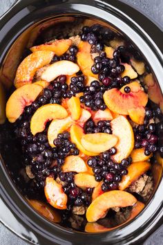 a crock pot filled with blueberries and peaches