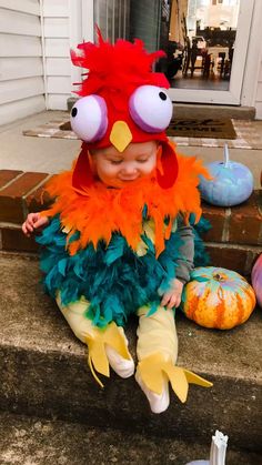 a small child in a costume sitting on the steps