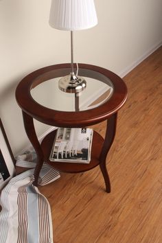 a table with a magazine on it and a lamp in the corner next to it