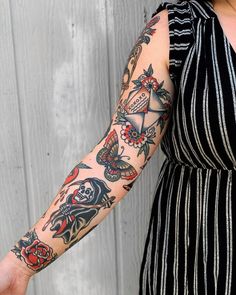 a woman wearing a black and white dress holding her arm with tattoos on both sides