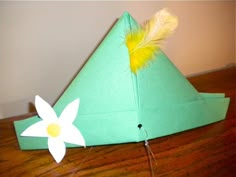 a paper hat with a flower on the side and a feather sticking out of it