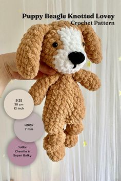 a crocheted dog is being held in front of a curtain with the words puppy beagle knotted lovey crochet pattern below it